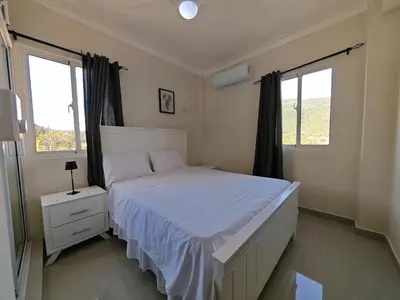 a bedroom with a white bed and two windows at 2 Bdrm, 1 Bath, Wifi, Near River and Beach, 3R in Paraíso