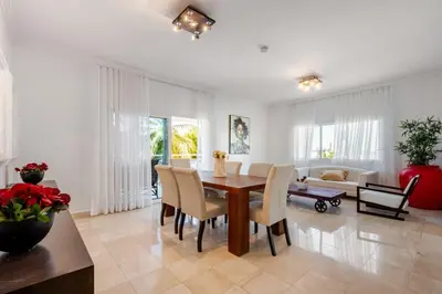 a living room with a wooden table and chairs at First Line, Direct Access to Private Beach in Punta Cana
