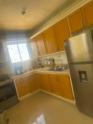 a kitchen with wooden cabinets and a stainless steel refrigerator at Tu escape natural - No incluye bebidas, tiene costo adicional in Miches