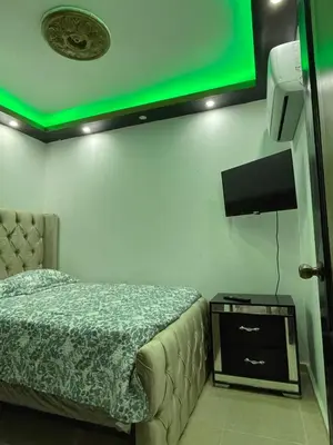 a bedroom with a bed and a green light at Apartamento a 15 minutos de la playa in Imbert