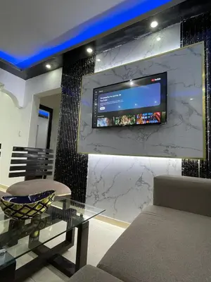 a living room with a table and a tv on a wall at Departamento a 15 minutos de la playa in Imbert