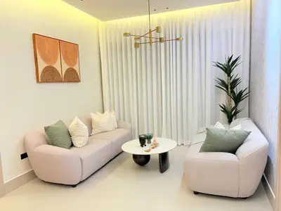 a living room with two chairs and a table at Apartment in Evaristo Morales, National District in Santo Domingo