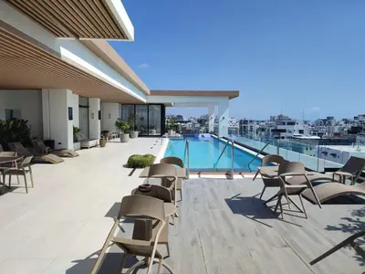 a balcony with chairs and a swimming pool on a building at Apartment in Evaristo Morales, National District in Santo Domingo