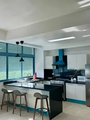 a kitchen with a counter and two stools in it at Juan Dolio 2BR Apt Beach front in Juan Dolio