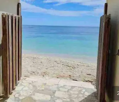 an open door to the beach with the ocean behind it at Juan Dolio 2BR Apt Beach front in Juan Dolio