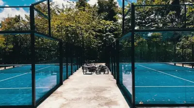 a tennis court with a table and chairs on a tennis court at Oceanfront Unit Jacuzzi Balconies of Atlantic in El Limón