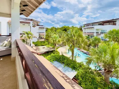 an apartment balcony with a view of a pool and palm trees at Oceanfront PH Jacuzzi Balconies of the Atlanti in El Limón