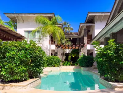 an exterior view of a house with a swimming pool at Villa 1 min walk from the beach in Las Terranas in El Limón