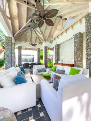 a living room with white couches and a ceiling fan at Villa 1 min walk from the beach in Las Terranas in El Limón