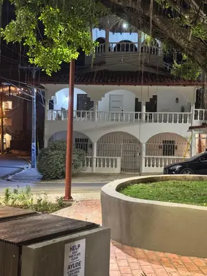 a large white building with a sign in front of it at Alma Stay Central and cozy in Santa Bárbara de Samaná