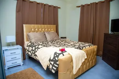 a bedroom with a bed and a dresser and a television at Modern 2BR Piscina BBQ Close To Kite Beach in Cabarete