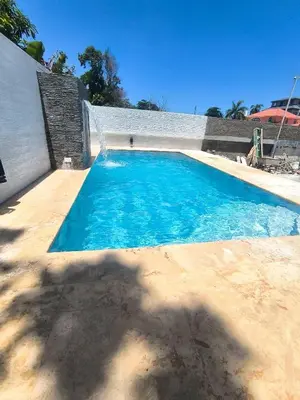 a swimming pool with blue water in a backyard at Modern 2BR Piscina BBQ Close To Kite Beach in Cabarete