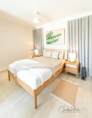 a bedroom with a large bed and two night stands at Modern Caribbean Stay Coral Azul 301 in La Laguna