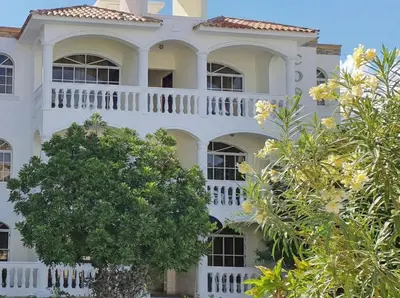 a large white building with a balcony at 2-Bedroom Beach Apartment 50m from the Sea and Pool in San Felipe de Puerto Plata