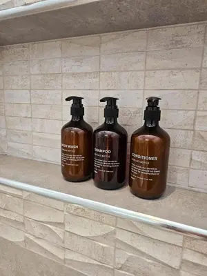 three bottles of soap sitting on a shelf at Aqua Esmeralda Beachfront Apartment Trinidad 103 in La Laguna