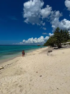 two people standing on a beach near the ocean at Aqua Esmeralda Beachfront Apartment Trinidad 103 in La Laguna