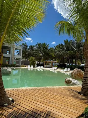 a large swimming pool with palm trees and chairs at Aqua Esmeralda Beachfront Apartment Trinidad 103 in La Laguna