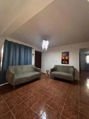 two couches in a living room with blue curtains at Beautiful Quiet shared home in Santo Domingo
