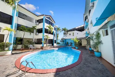 a swimming pool in front of a building at Cheap Hotel Room in Sosua Center in Sosúa