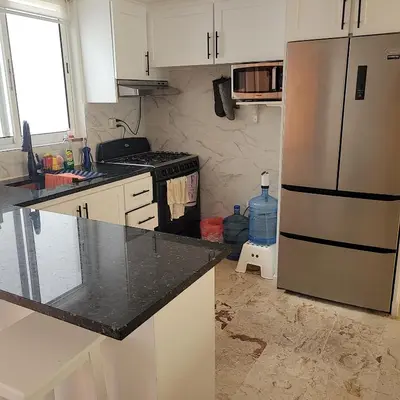 a kitchen with white cabinets and a stainless steel refrigerator at my paradise in Punta Cana