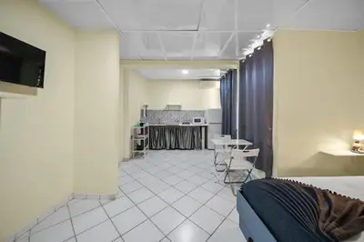 a room with a bed and a table and a kitchen at Cheap Hotel Room in Sosua Strip in Sosúa