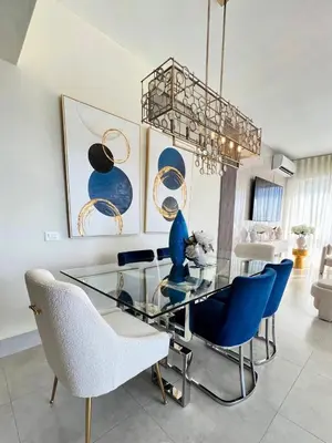 a dining room with a glass table and blue chairs at Majestic 2Bd Ocean view Apartment Boca Del Mar III in Boca Chica