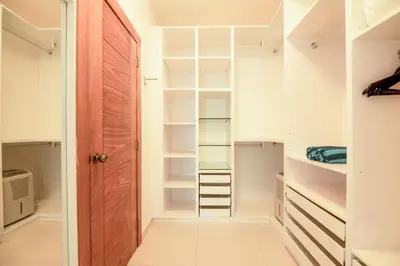 a walk in closet with white walls and a wooden door at Lux villa playa bonita in Las Terrenas