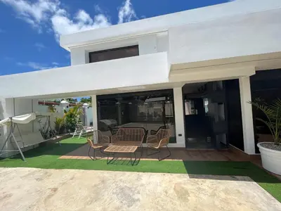 a white house with chairs and a patio at Villa fantastica Pool privada y centrica in Las Terrenas