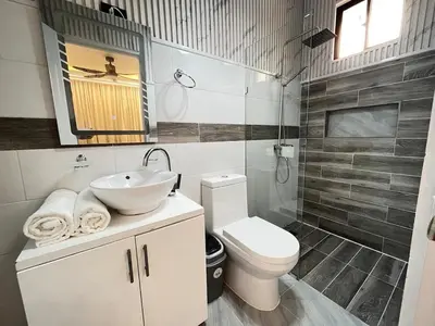 a bathroom with a sink and a toilet and a mirror at Villa fantastica Pool privada y centrica in Las Terrenas