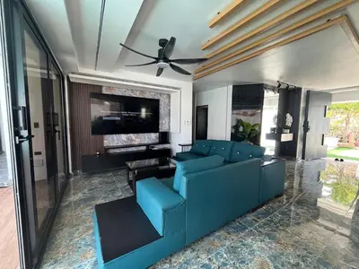 a living room with a blue couch and a ceiling fan at Villa fantastica Pool privada y centrica in Las Terrenas