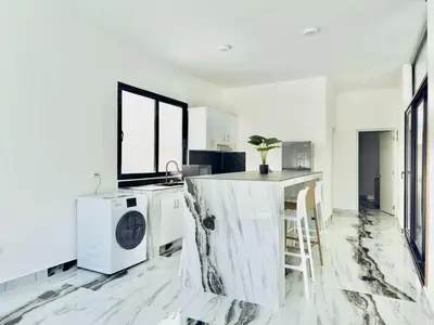 a white kitchen with a washer and dryer in it at Villa Las Terrenas Near Playa Bonita Pool in Las Terrenas