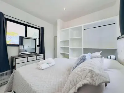 a white bedroom with a large bed and a television at Villa Las Terrenas Cosón minutes Pool and AC in Las Terrenas