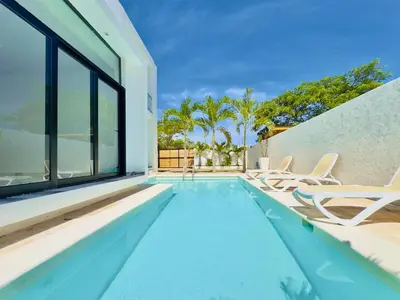 a swimming pool with chairs and a house at Villa Las Terrenas walk to Punta Popy Pool, AC in Las Terrenas