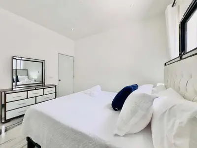 a white bedroom with a white bed and a mirror at Villa Las Terrenas walk to Punta Popy Pool, AC in Las Terrenas