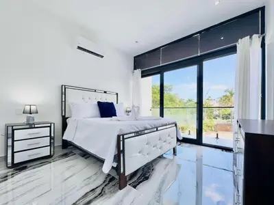 a white bedroom with a bed and a large window at Villa Las Terrenas walk to Punta Popy Pool, AC in Las Terrenas