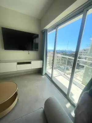a living room with a large tv and large windows at BoCA DEL MAR 3 BOCA CHICA in Boca Chica