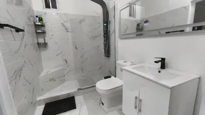 a bathroom with a shower and a toilet and a sink at 1BR Studio with Pool, Fast Wi-Fi, Walk to Beach in Sosúa