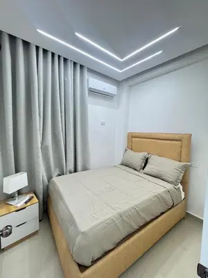a bedroom with a bed and a window with curtains at Hotel Evers in Azua
