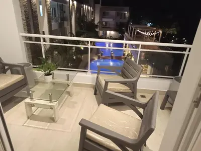 a balcony with chairs and a table on a ship at Cozy tiny home by the beach in La Laguna