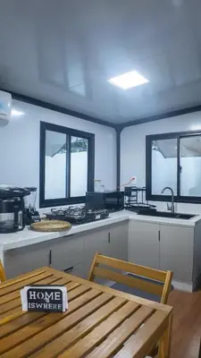 a kitchen with a table and a stove and windows at Cozy tiny home by the beach in La Laguna