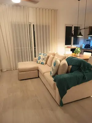 a living room with a white couch and a tv at Cozy tiny home by the beach in La Laguna