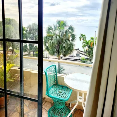 a balcony with a table and chairs and a view of the ocean at Hotel La Llave Del Mar in Santo Domingo