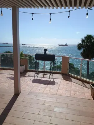 a grill on a patio overlooking the ocean at Hotel La Llave Del Mar in Santo Domingo
