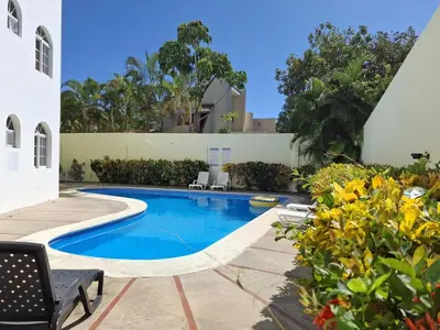 a swimming pool in the backyard of a house at Ocean Breeze 2BR Apt 50m to Beach Pool AC in San Felipe de Puerto Plata