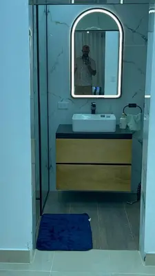 a man taking a picture of a bathroom with a mirror at D Gomez House in Santiago de los Caballeros