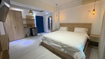 a bedroom with a large bed and a kitchen at Hotel Juan Dolio in Juan Dolio