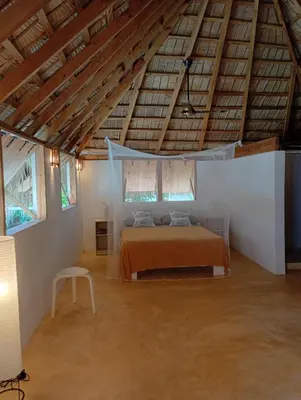 a bedroom with a bed in a room with wooden ceilings at Mejor, Quédate Aquí in Las Galeras
