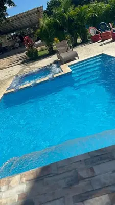a large blue swimming pool with a chair in it at Rancho Paraíso Escondido