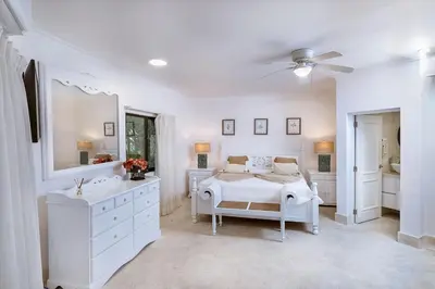 a white bedroom with a bed and a mirror at Villa Reme 19 in La Romana