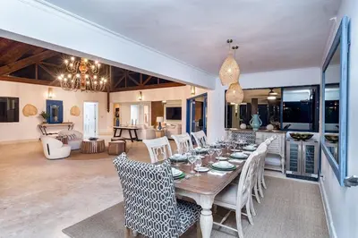 a dining room and living room with a table and chairs at Villa Reme 19 in La Romana